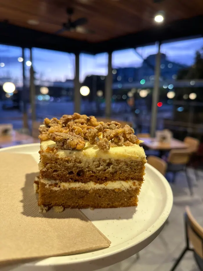 A slice of carrot cake with sugared walnuts