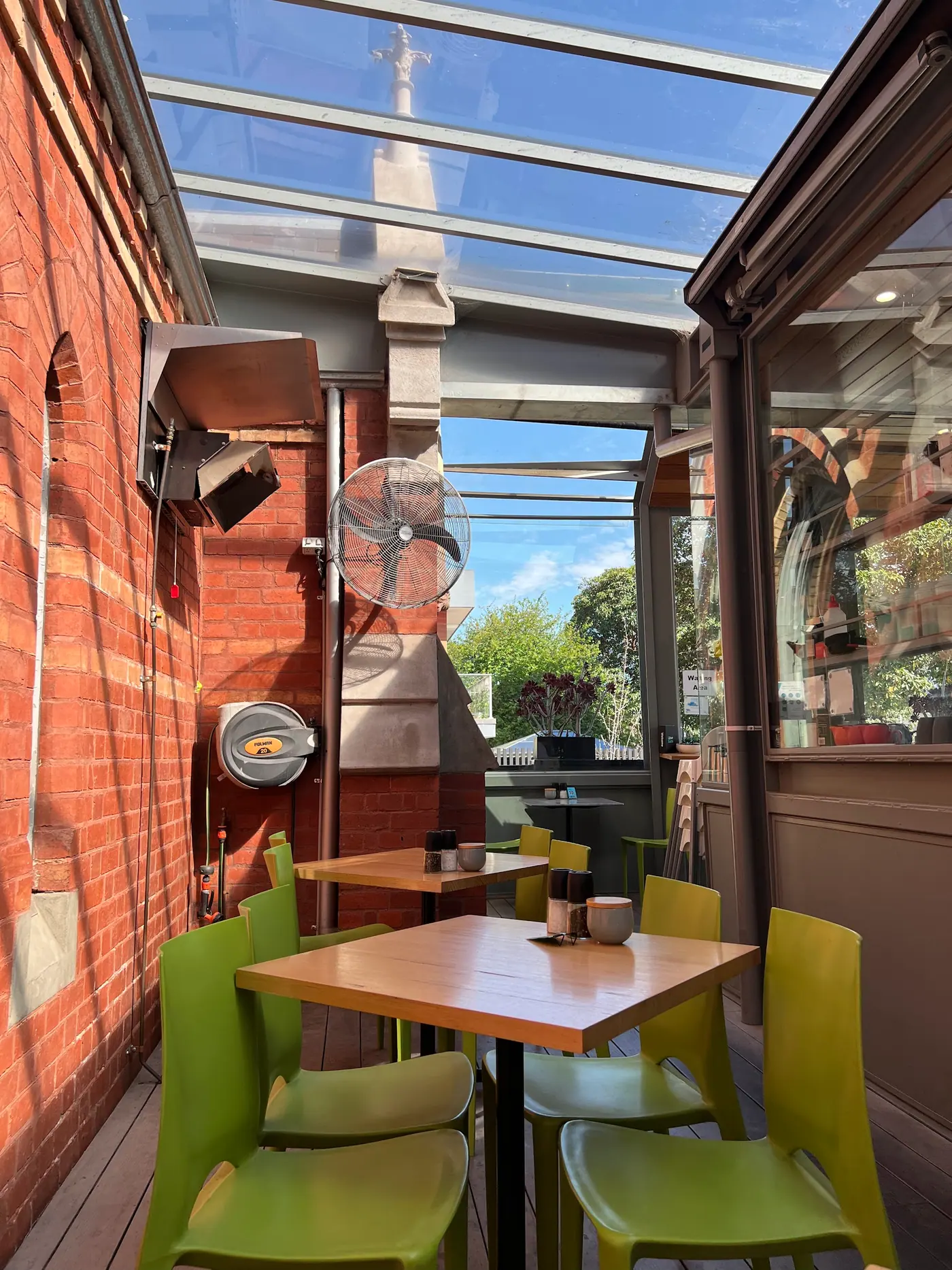 Lime green chairs under the church windows in the sunny glass courtyard